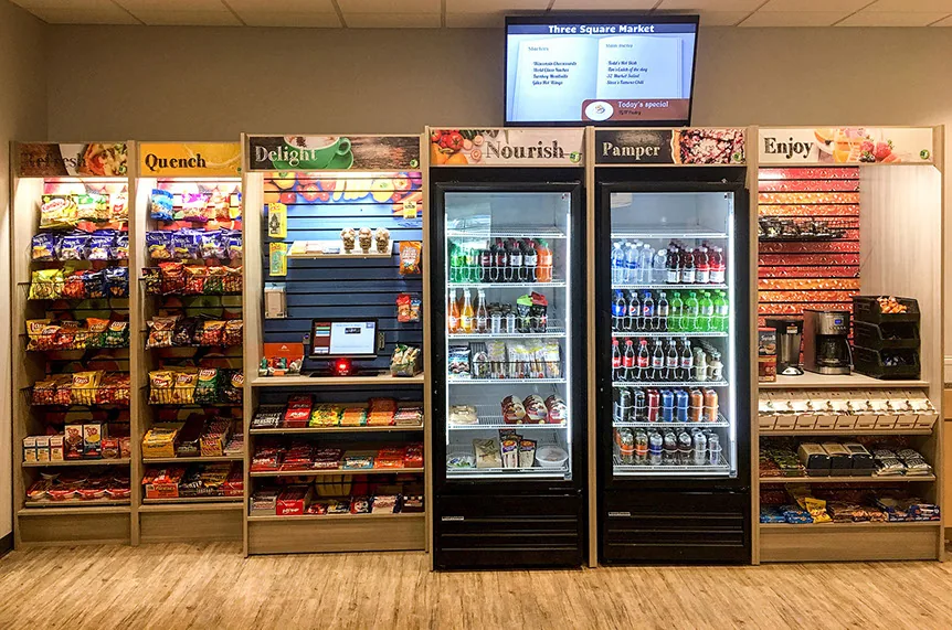 A&M micro market with open shelves, coolers and self-checkout kiosk